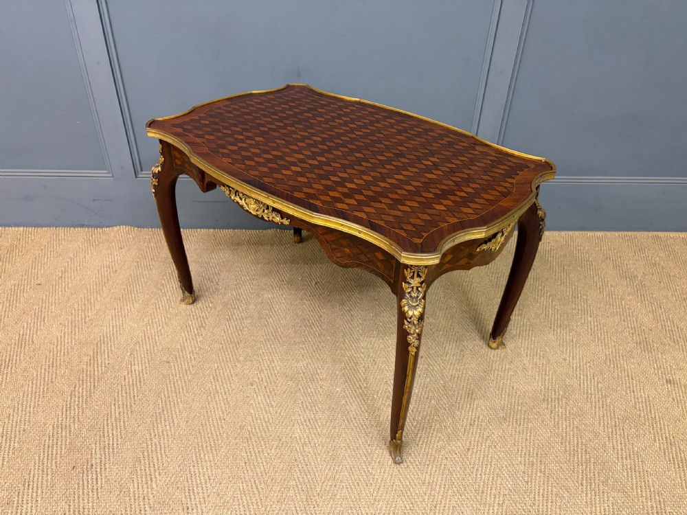 A French Louis XV style low coffee table featuring a serpentine parquetry top, curved cabriole legs, and ornate gilt-bronze mounts. View XIII