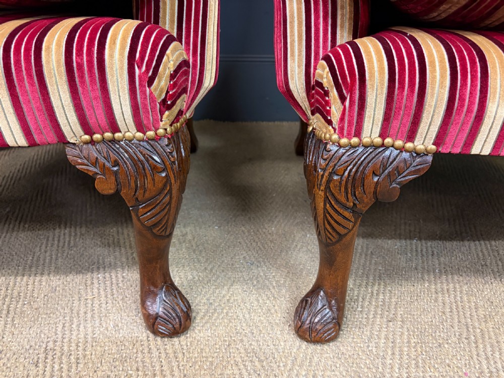 A pair of high-backed wing armchairs upholstered in red and gold striped velvet fabric with carved timber cabriole legs. View VI