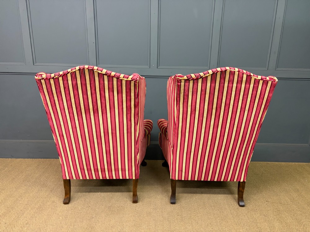 A pair of high-backed wing armchairs upholstered in red and gold striped velvet fabric with carved timber cabriole legs. View IX
