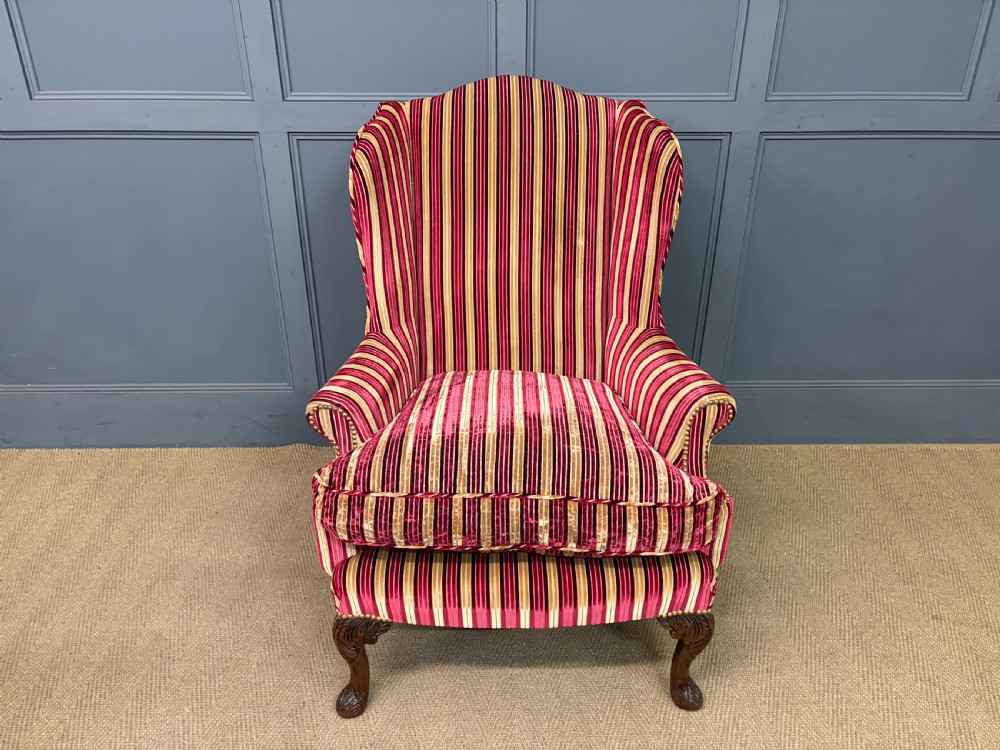 A pair of high-backed wing armchairs upholstered in red and gold striped velvet fabric with carved timber cabriole legs. View X