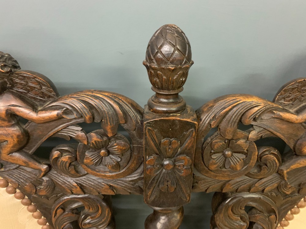 A 19th-century Carolean style carved walnut settee with three oval back panels upholstered in cream damask fabric, featuring barley twist uprights and intricate scrollwork. View IV