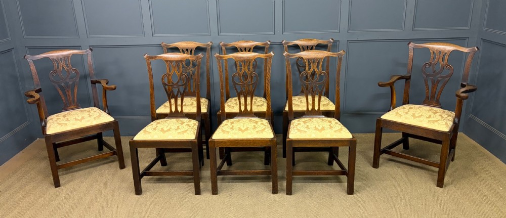A set of eight brown oak Chippendale dining chairs including two armchairs and six side chairs with patterned fabric drop-in seats. View IV