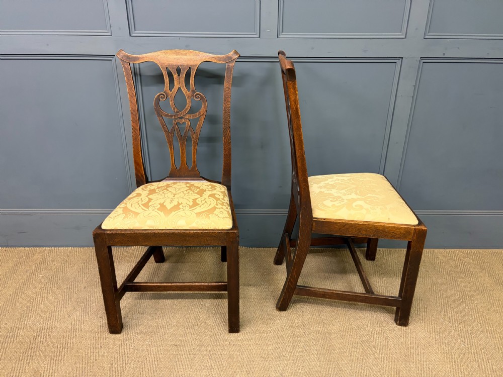 A set of eight brown oak Chippendale dining chairs including two armchairs and six side chairs with patterned fabric drop-in seats. View V