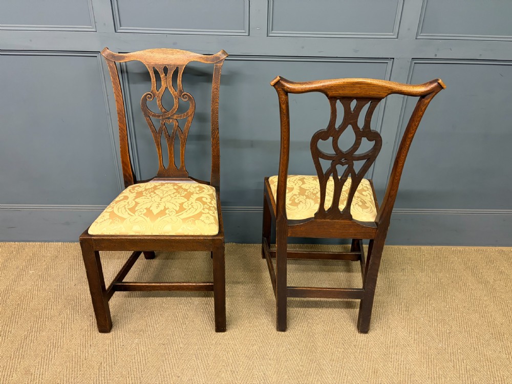 A set of eight brown oak Chippendale dining chairs including two armchairs and six side chairs with patterned fabric drop-in seats. View VI