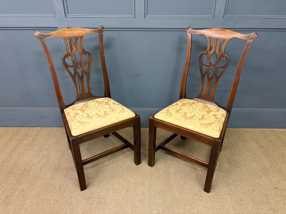 A set of eight brown oak Chippendale dining chairs including two armchairs and six side chairs with patterned fabric drop-in seats. View VII