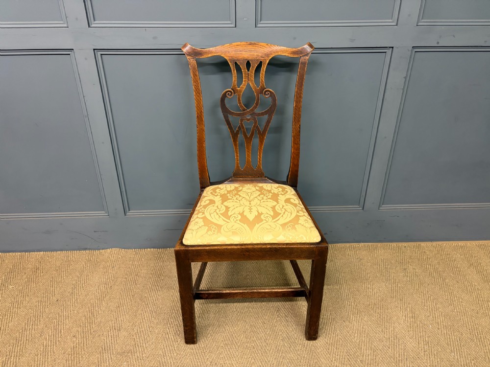 A set of eight brown oak Chippendale dining chairs including two armchairs and six side chairs with patterned fabric drop-in seats. View VIII