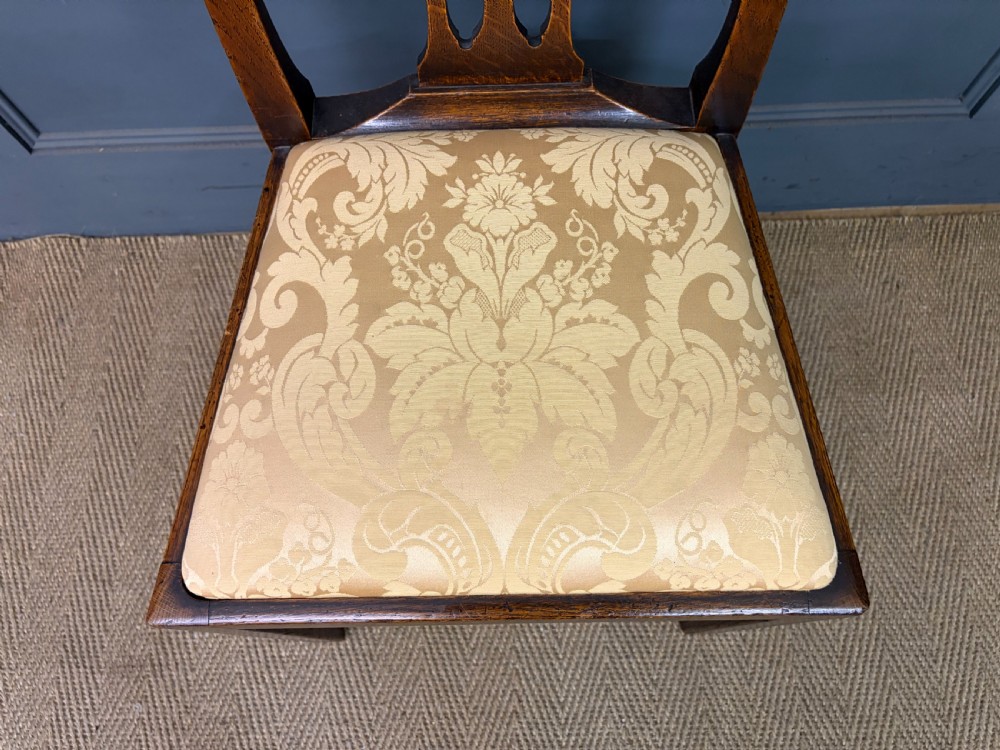A set of eight brown oak Chippendale dining chairs including two armchairs and six side chairs with patterned fabric drop-in seats. View IX