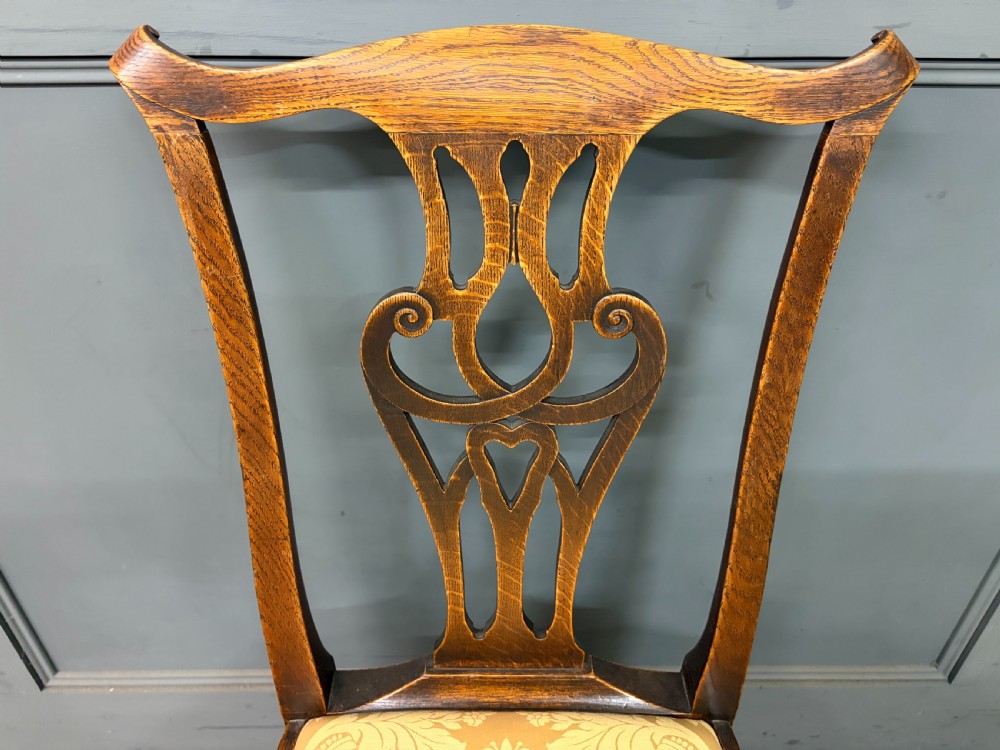 A set of eight brown oak Chippendale dining chairs including two armchairs and six side chairs with patterned fabric drop-in seats. View X
