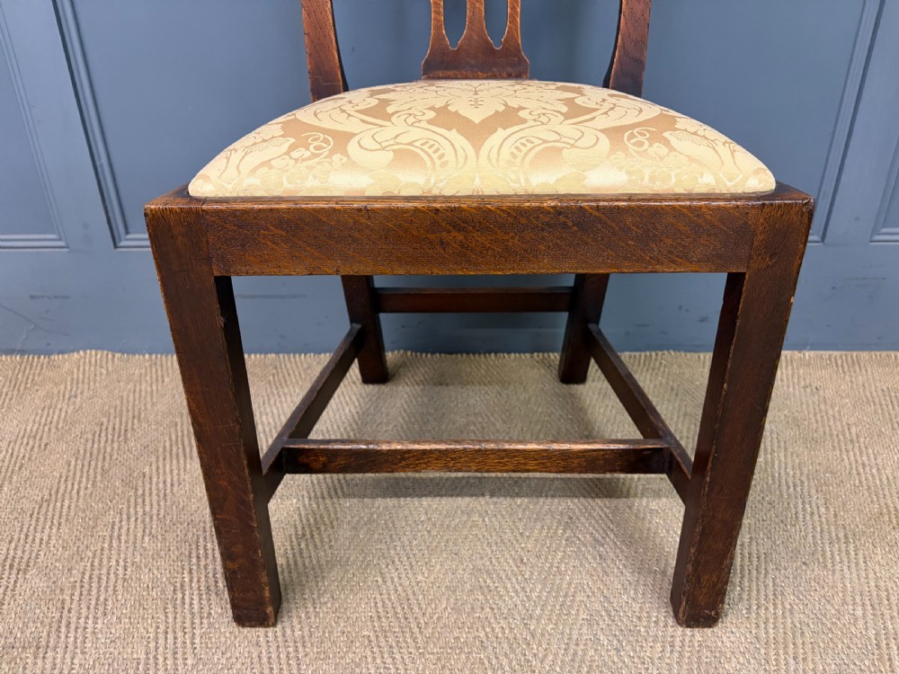 A set of eight brown oak Chippendale dining chairs including two armchairs and six side chairs with patterned fabric drop-in seats. View XI