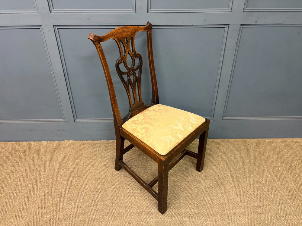 A set of eight brown oak Chippendale dining chairs including two armchairs and six side chairs with patterned fabric drop-in seats. View XII