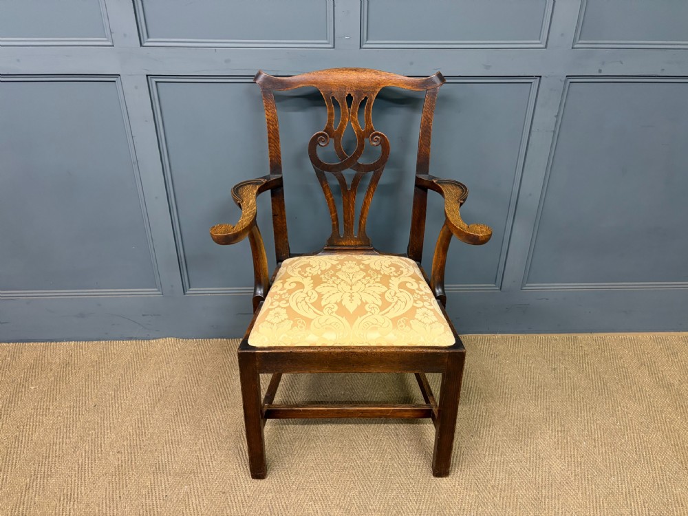 A set of eight brown oak Chippendale dining chairs including two armchairs and six side chairs with patterned fabric drop-in seats. View XVI