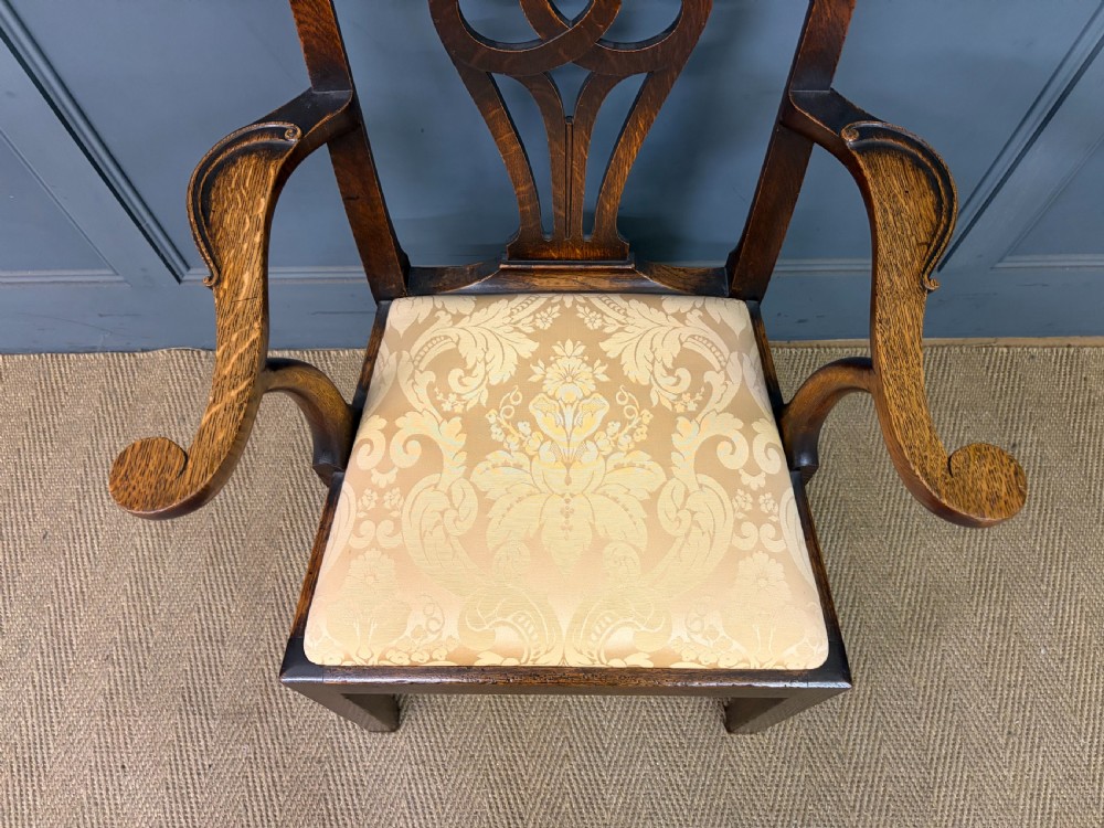 A set of eight brown oak Chippendale dining chairs including two armchairs and six side chairs with patterned fabric drop-in seats. View XVII