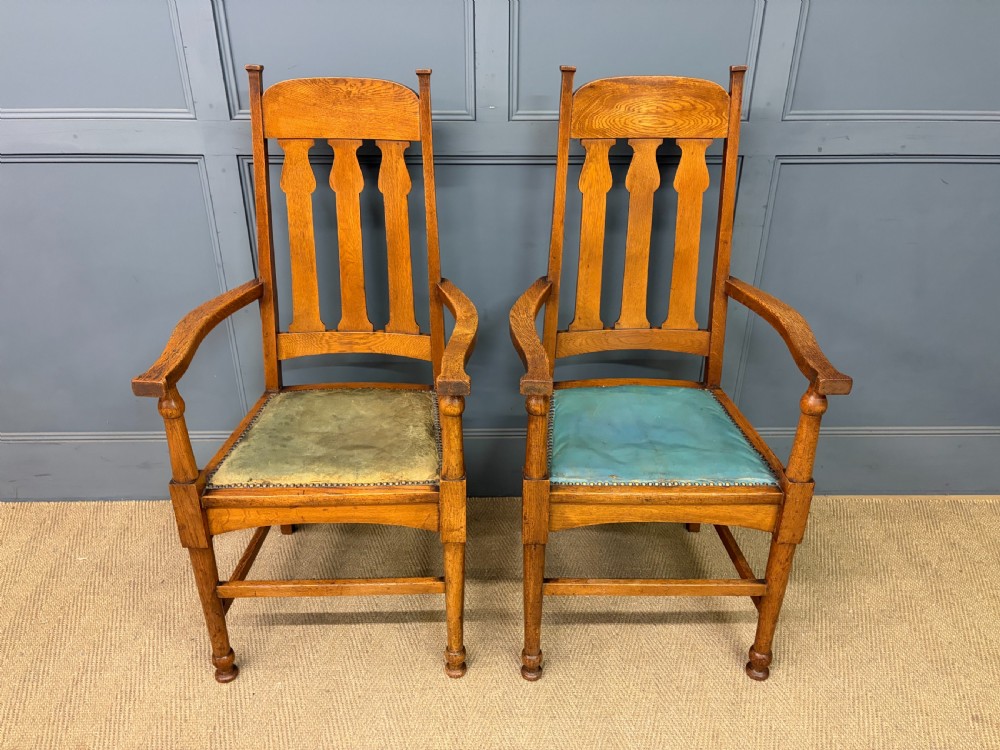 A pair of high-backed Arts and Crafts oak armchairs with vertical back splats and studded leather seats. View III