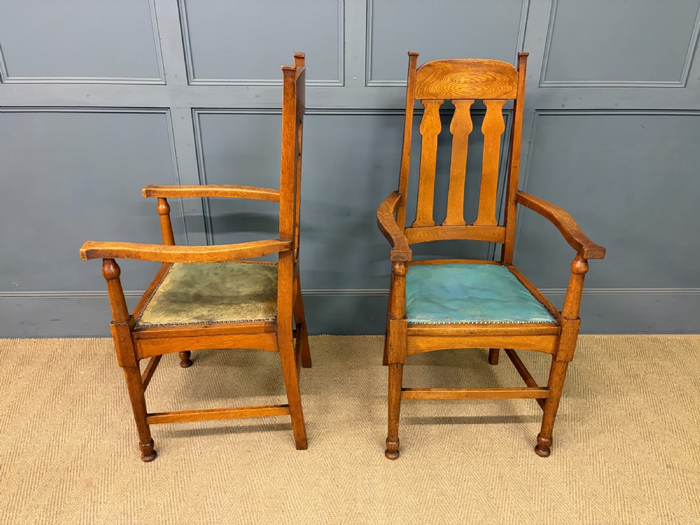 A pair of high-backed Arts and Crafts oak armchairs with vertical back splats and studded leather seats. View IV