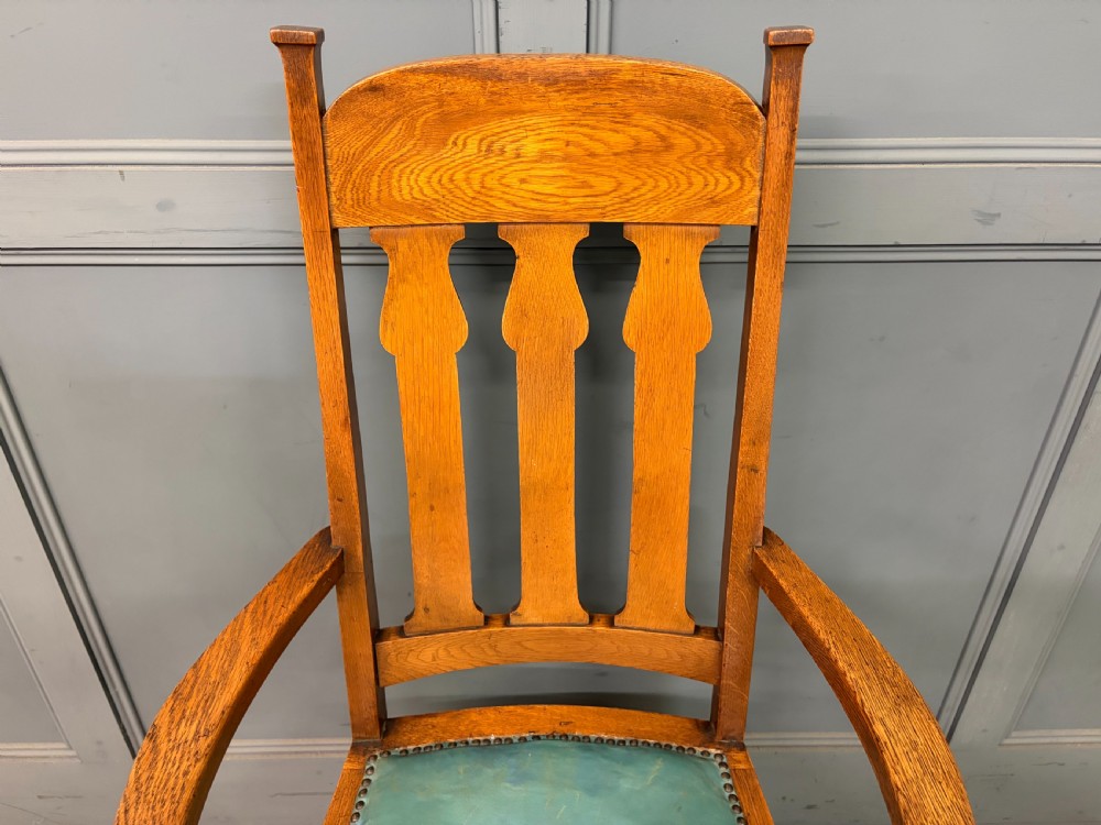 A pair of high-backed Arts and Crafts oak armchairs with vertical back splats and studded leather seats. View VIII