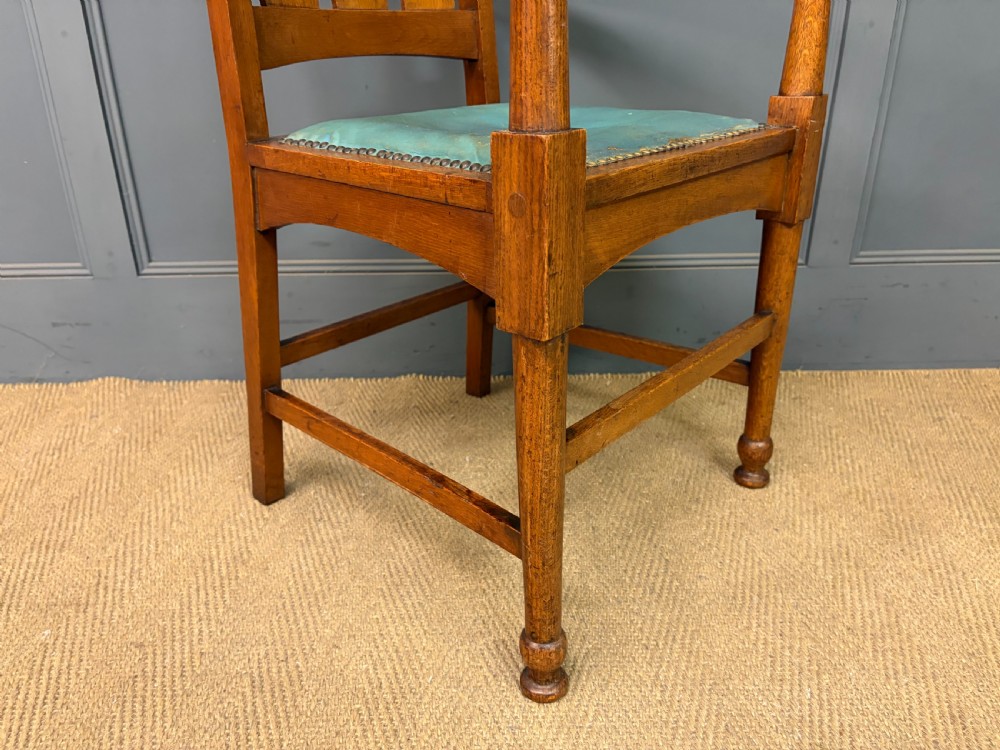 A pair of high-backed Arts and Crafts oak armchairs with vertical back splats and studded leather seats. View XI