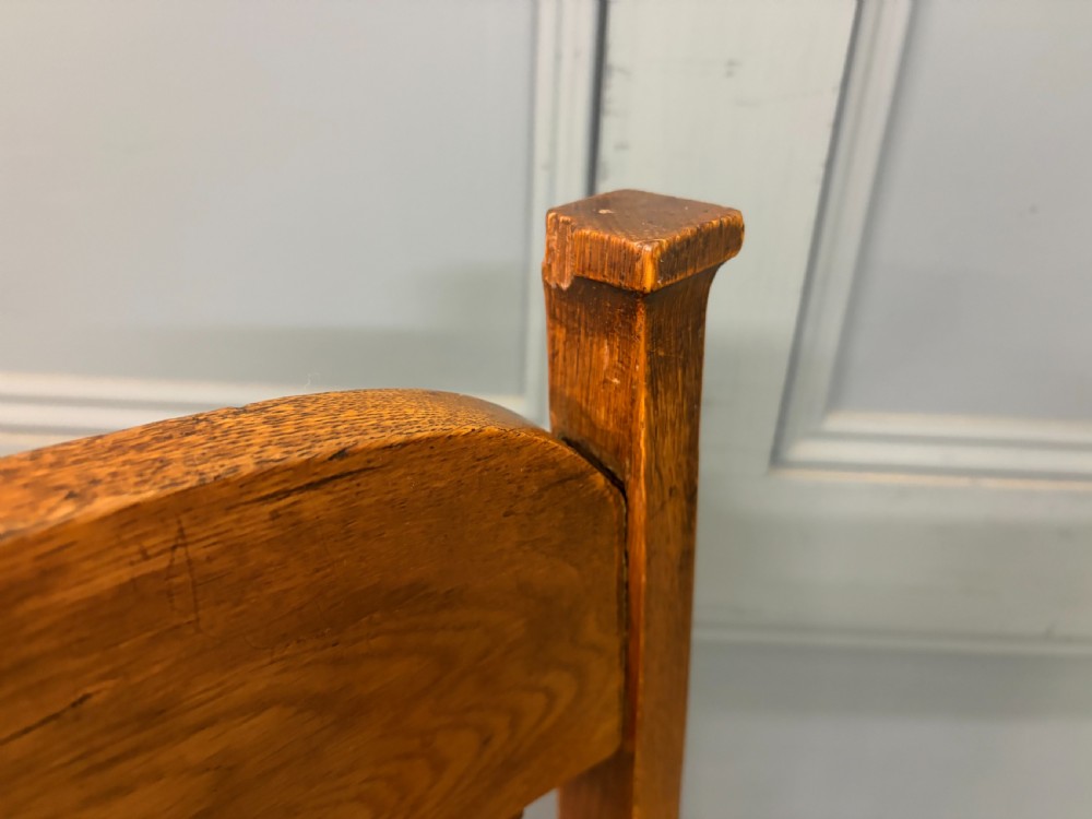 A pair of high-backed Arts and Crafts oak armchairs with vertical back splats and studded leather seats. View XII