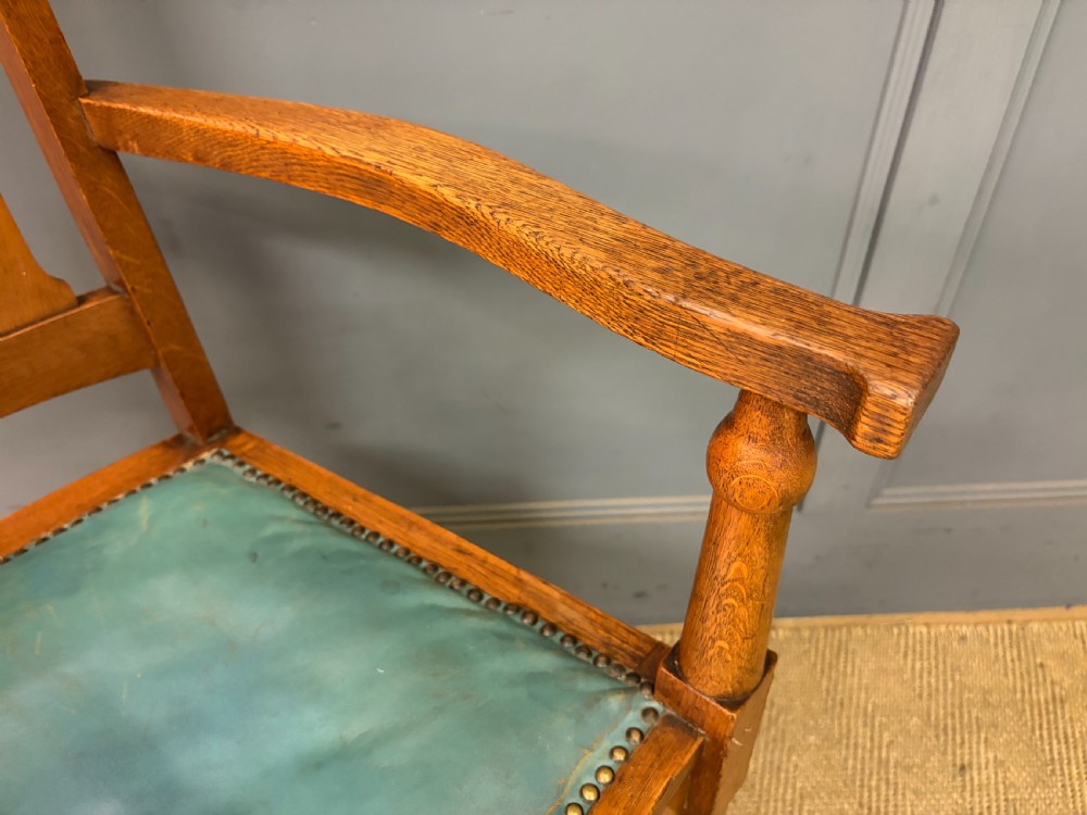 A pair of high-backed Arts and Crafts oak armchairs with vertical back splats and studded leather seats. View XIII