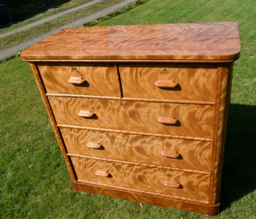 fig 6. Victorian golden birch chest of drawers featuring a two-over-three drawer configuration, rounded corners, integrated timber handles, and a plinth base.
