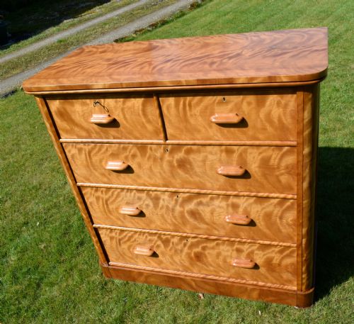 fig 7. Victorian golden birch chest of drawers featuring a two-over-three drawer configuration, rounded corners, integrated timber handles, and a plinth base.