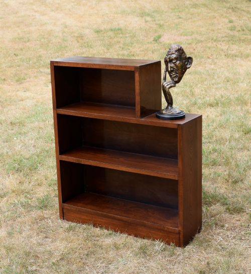 fig 1. A dark brown wooden Art Deco bookcase featuring an asymmetrical stepped design with three open shelves.