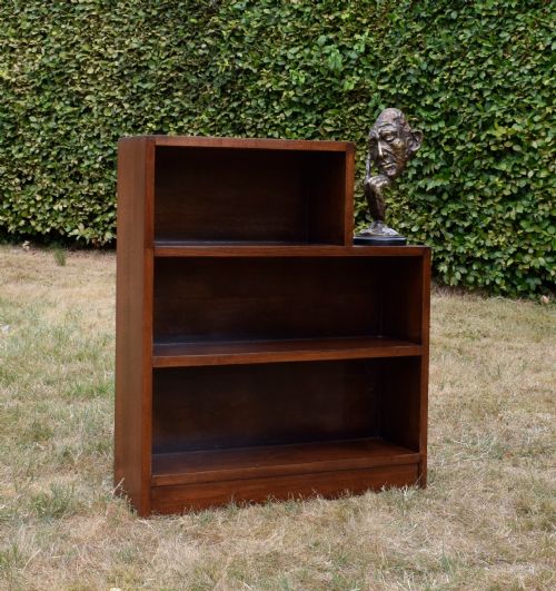 fig 2. A dark brown wooden Art Deco bookcase featuring an asymmetrical stepped design with three open shelves.