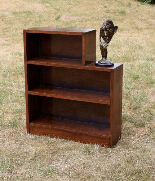 fig 3. A dark brown wooden Art Deco bookcase featuring an asymmetrical stepped design with three open shelves.