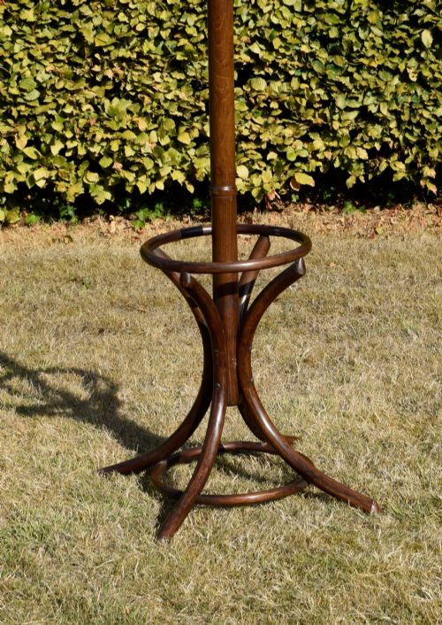 fig 4. A dark brown bentwood coat and hat stand featuring curved upper hooks, a turned central post, an umbrella ring, and curved tripod legs.