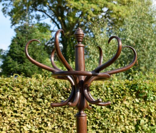 fig 5. A dark brown bentwood coat and hat stand featuring curved upper hooks, a turned central post, an umbrella ring, and curved tripod legs.