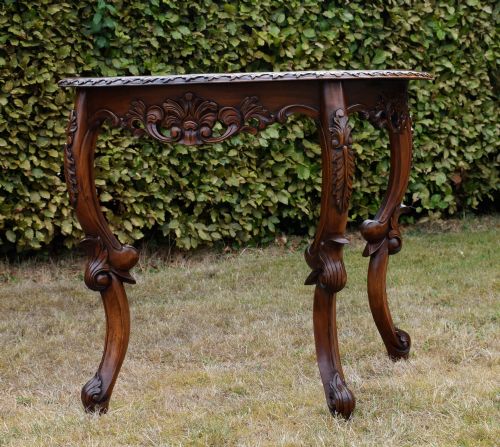 fig 3. A dark mahogany demi-lune console table featuring deep acanthus leaf carvings on the frieze and three cabriole legs.
