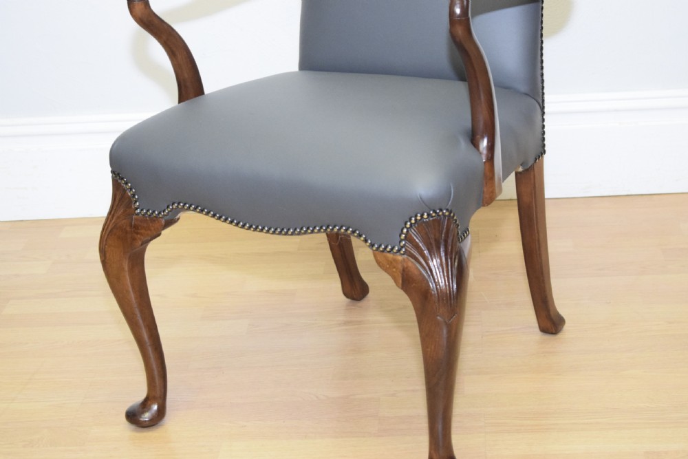 A Queen Anne style grey leather upholstered desk chair featuring carved mahogany cabriole legs, brass studding detail, and sweeping arms. View VI