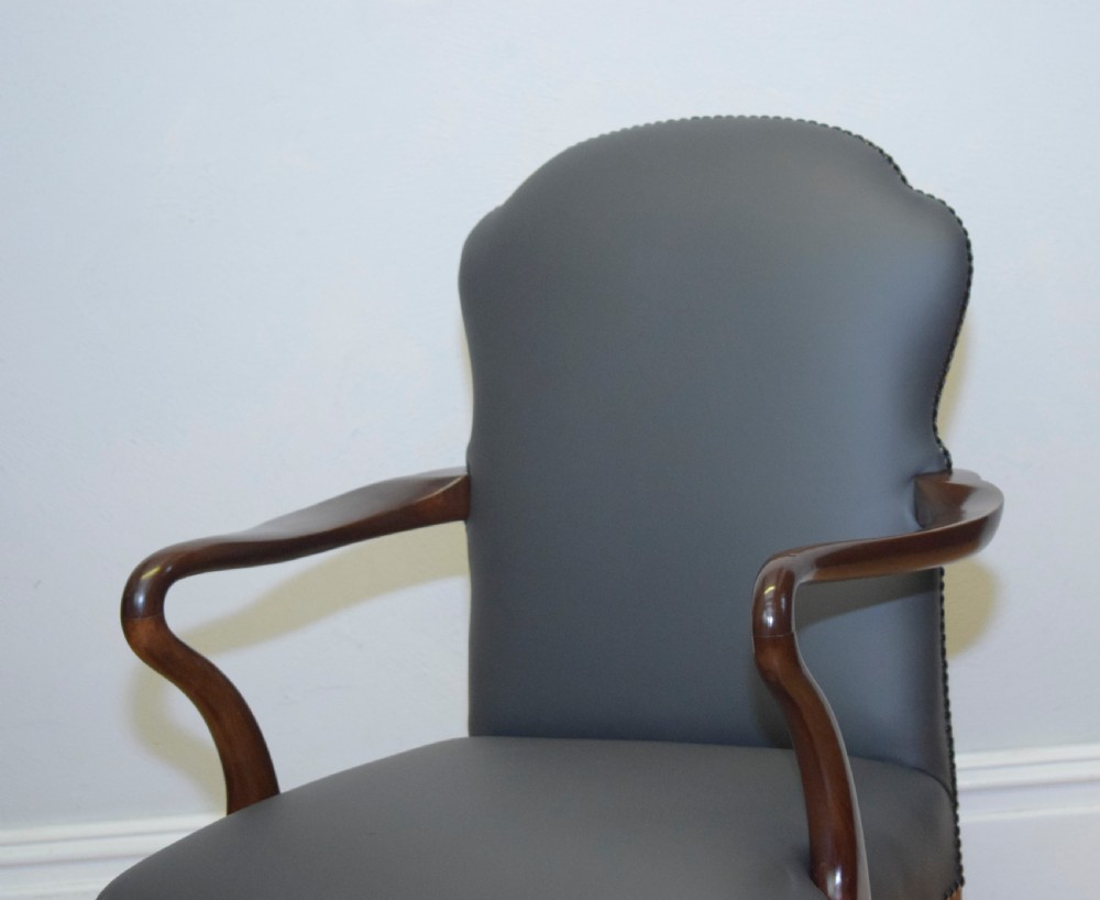 A Queen Anne style grey leather upholstered desk chair featuring carved mahogany cabriole legs, brass studding detail, and sweeping arms. View VIII