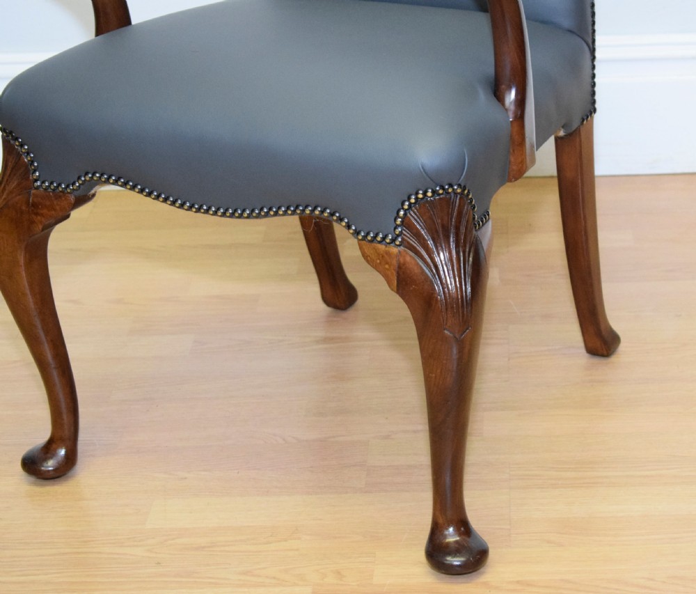A Queen Anne style grey leather upholstered desk chair featuring carved mahogany cabriole legs, brass studding detail, and sweeping arms. View X