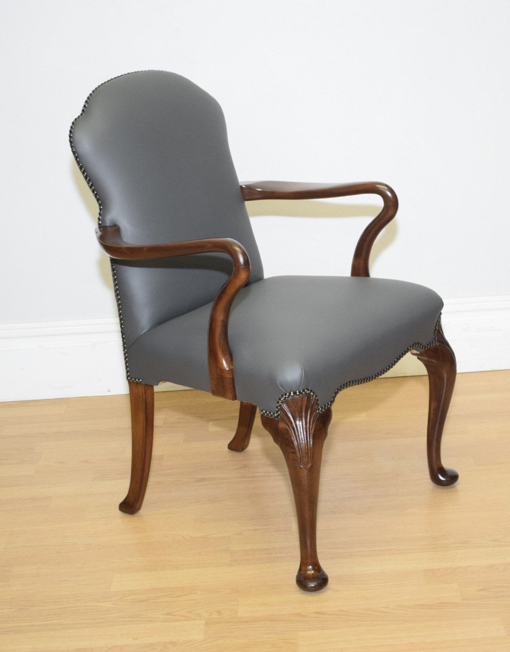 A Queen Anne style grey leather upholstered desk chair featuring carved mahogany cabriole legs, brass studding detail, and sweeping arms. View XIII