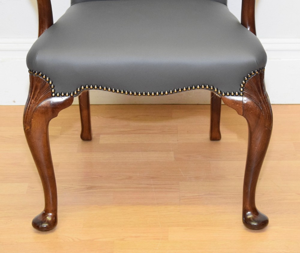 A Queen Anne style grey leather upholstered desk chair featuring carved mahogany cabriole legs, brass studding detail, and sweeping arms. View XVI