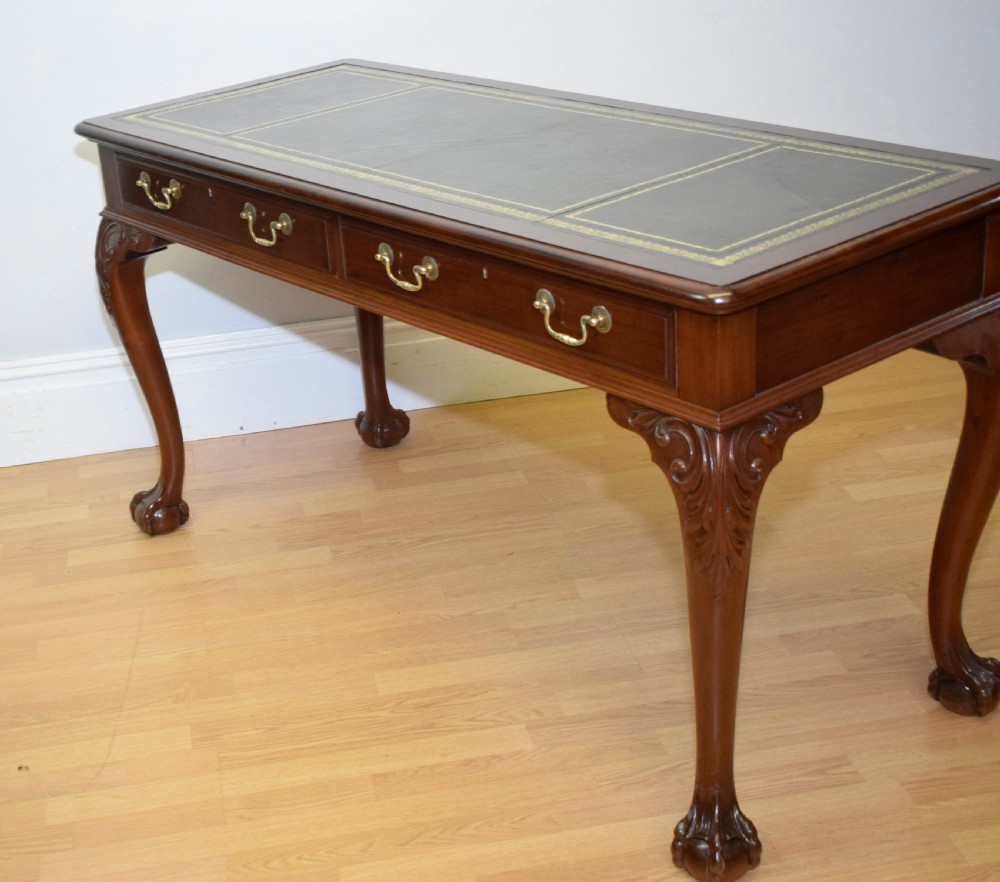 A mahogany library writing table featuring a green leather inset top, brass drop handles, and carved cabriole legs terminating in claw and ball feet. View XIII