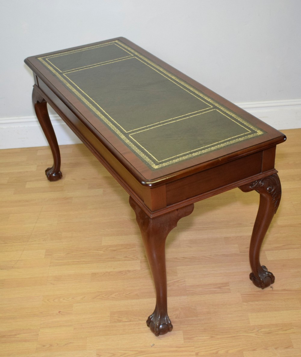 A mahogany library writing table featuring a green leather inset top, brass drop handles, and carved cabriole legs terminating in claw and ball feet. View XVI