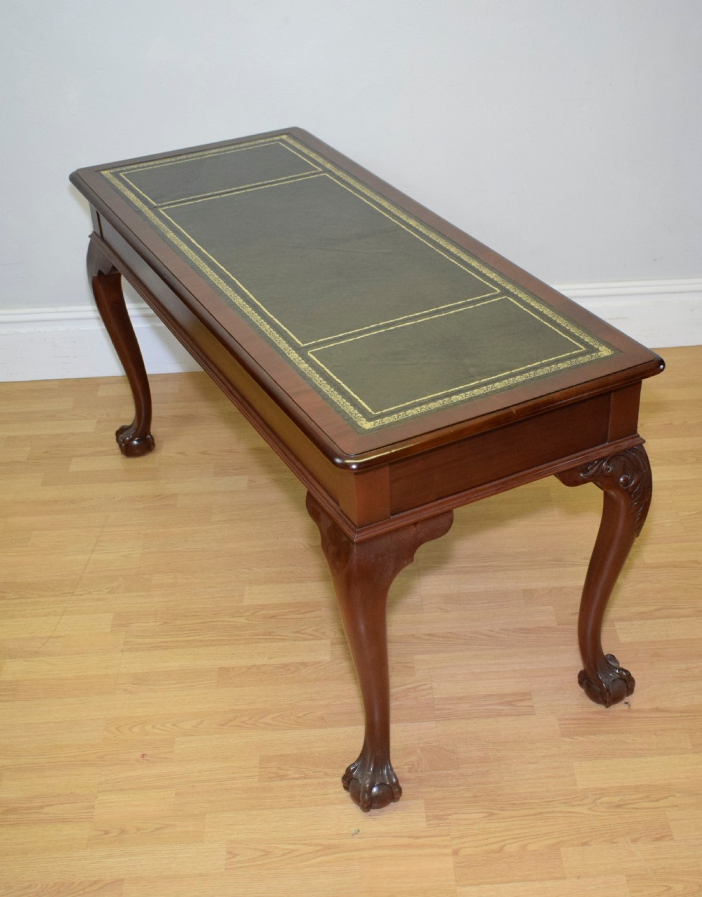 A mahogany library writing table featuring a green leather inset top, brass drop handles, and carved cabriole legs terminating in claw and ball feet. View XVII