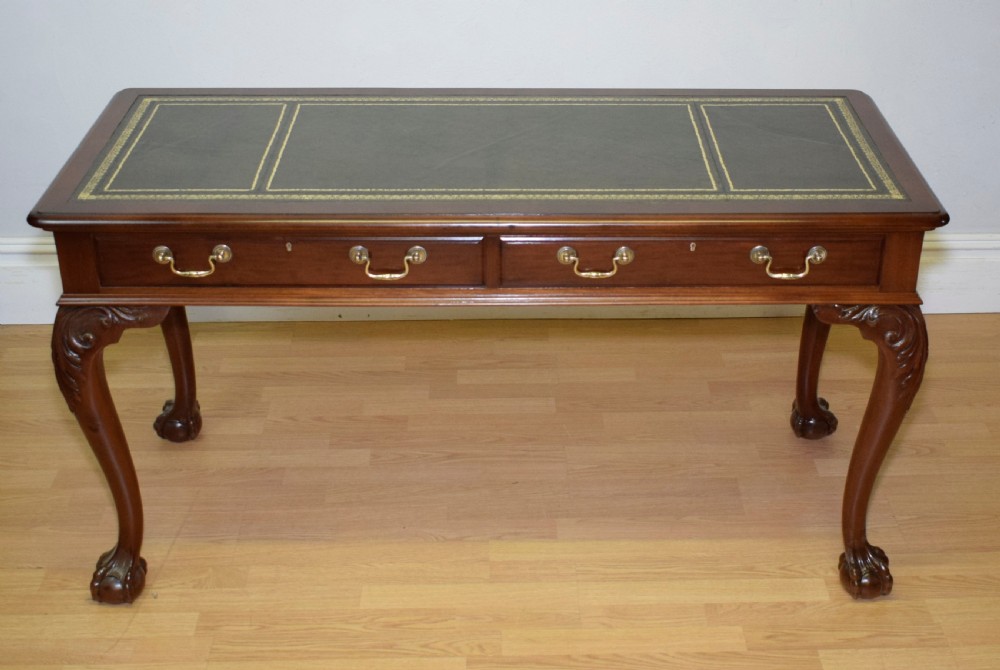 A mahogany library writing table featuring a green leather inset top, brass drop handles, and carved cabriole legs terminating in claw and ball feet. View XVIII