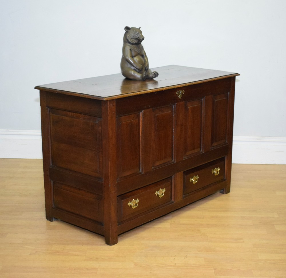 A dark Georgian oak mule chest featuring four fielded front panels and two lower drawers with brass swan-neck handles. View III