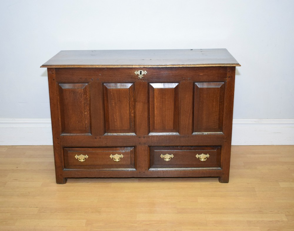 A dark Georgian oak mule chest featuring four fielded front panels and two lower drawers with brass swan-neck handles. View XI