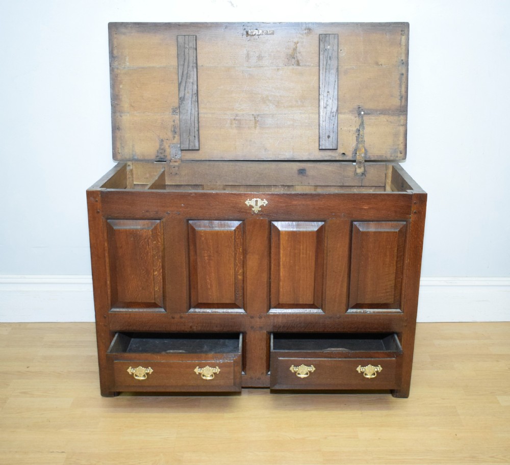 A dark Georgian oak mule chest featuring four fielded front panels and two lower drawers with brass swan-neck handles. View XII