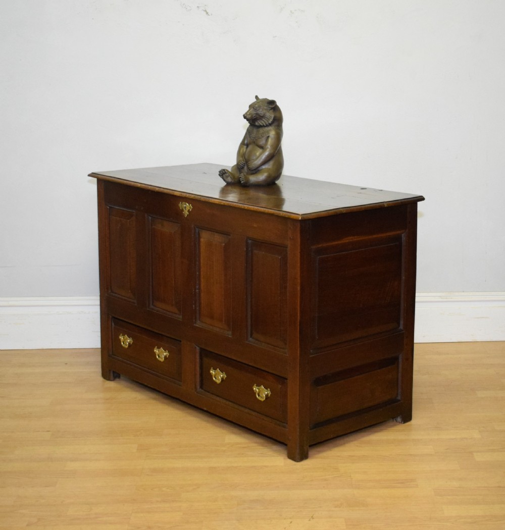 A dark Georgian oak mule chest featuring four fielded front panels and two lower drawers with brass swan-neck handles. View XV
