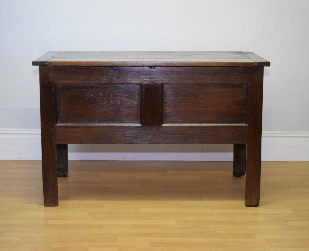 A dark oak seventeenth-century coffer featuring two plain rectangular front panels and a flat hinged top. View III