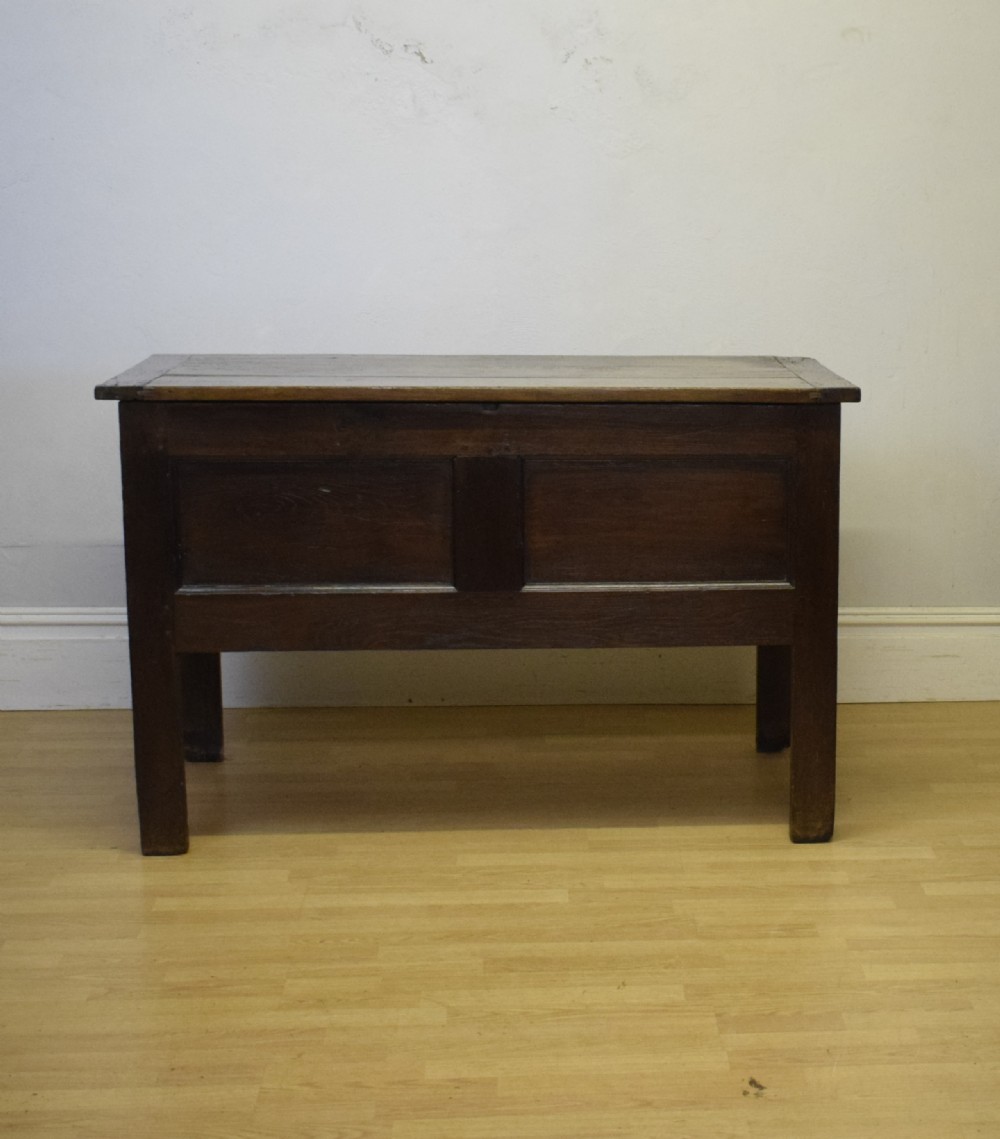 A dark oak seventeenth-century coffer featuring two plain rectangular front panels and a flat hinged top. View VI