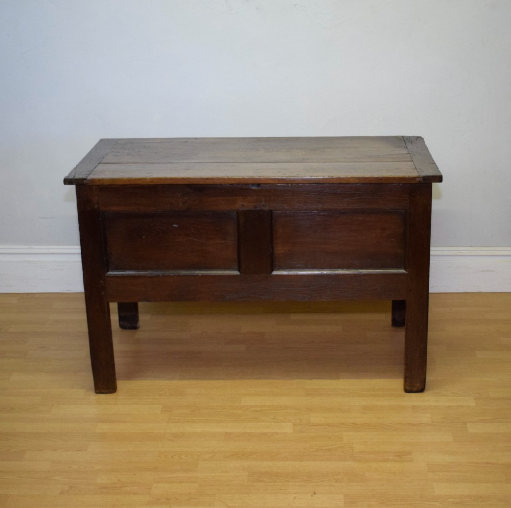 A dark oak seventeenth-century coffer featuring two plain rectangular front panels and a flat hinged top. View VII