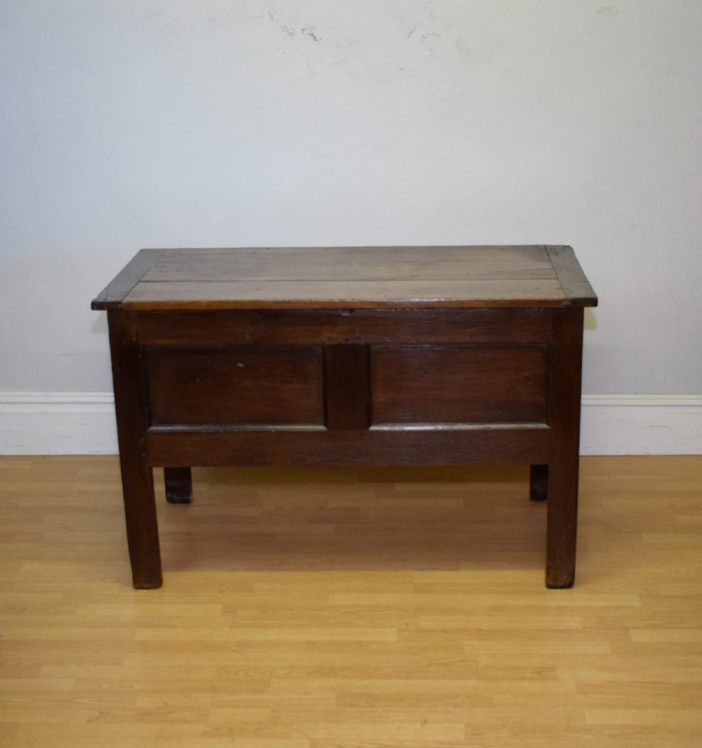 A dark oak seventeenth-century coffer featuring two plain rectangular front panels and a flat hinged top. View VIII