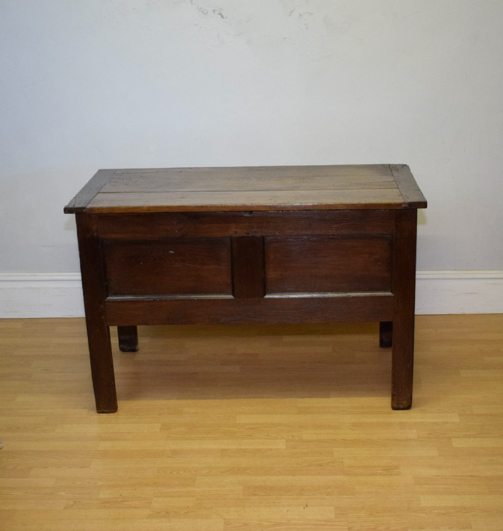 A dark oak seventeenth-century coffer featuring two plain rectangular front panels and a flat hinged top. View IX