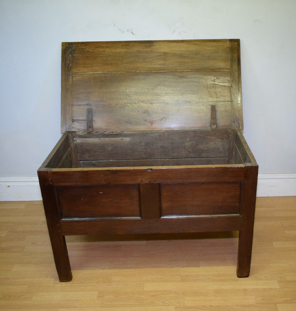A dark oak seventeenth-century coffer featuring two plain rectangular front panels and a flat hinged top. View X
