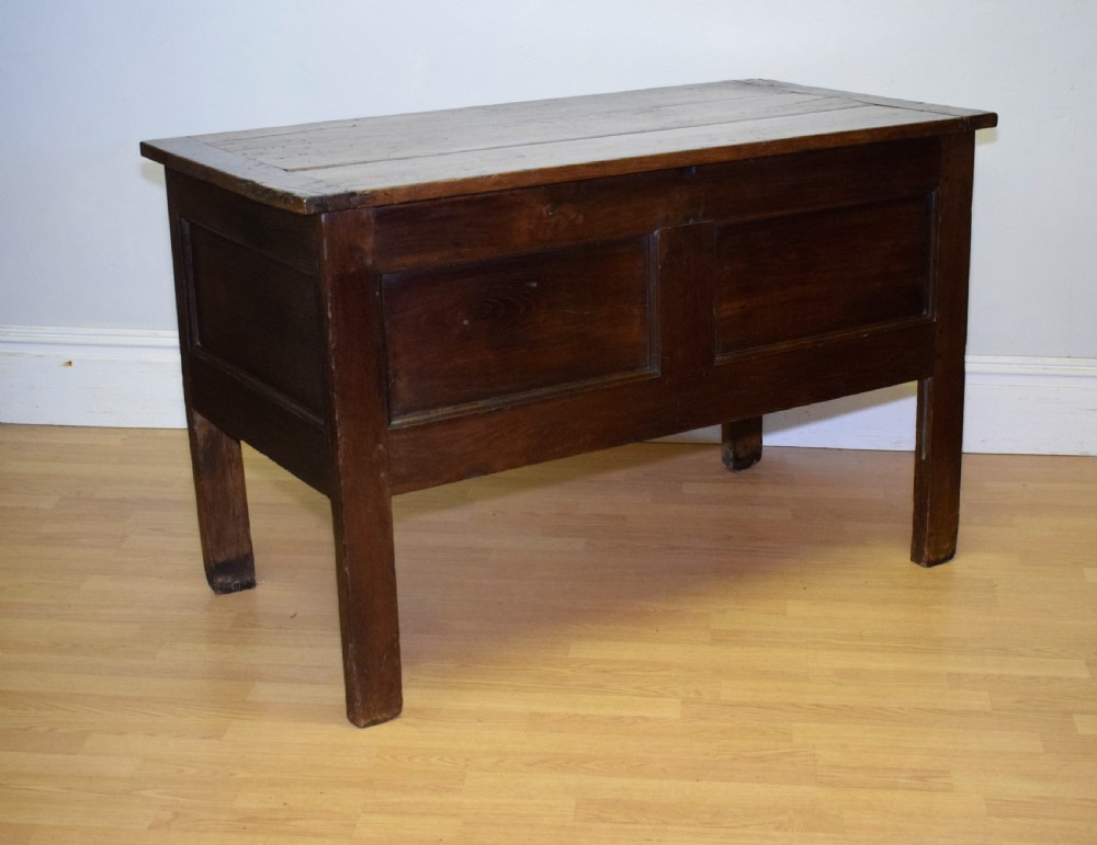 A dark oak seventeenth-century coffer featuring two plain rectangular front panels and a flat hinged top. View XI